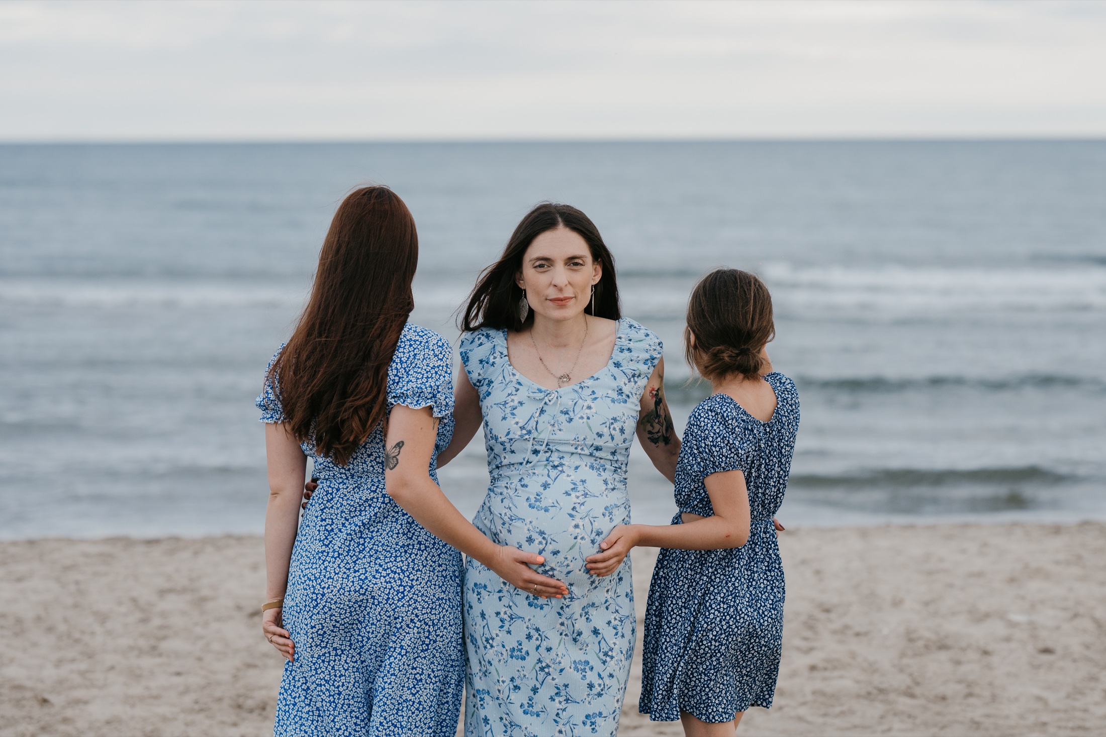 Une future maman entourée de ses filles sur la plage