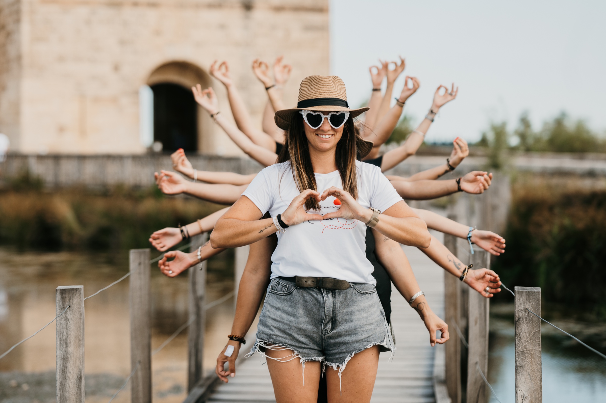 La future mariée entourée par les mains de ses amies